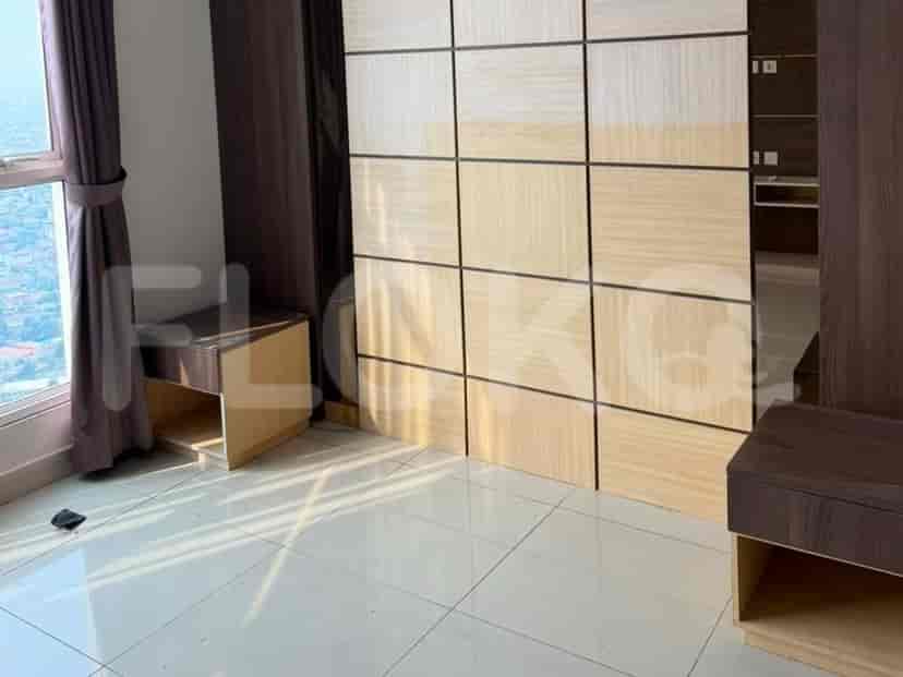 A bedroom with a queen-sized bed, a nightstand, and a large wardrobe with wooden panels.