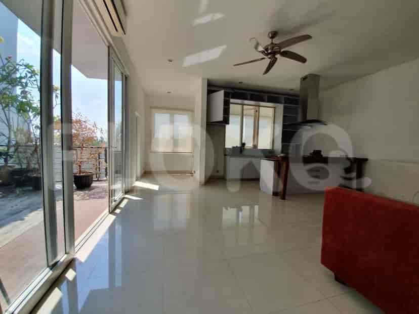 Area tamu dan dapur terbuka dengan kipas angin langit-langit, pulau dapur, dan pintu kaca geser besar yang terbuka ke balkon.