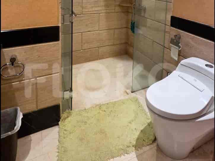 Shower dengan pintu kaca dan dinding berubin.