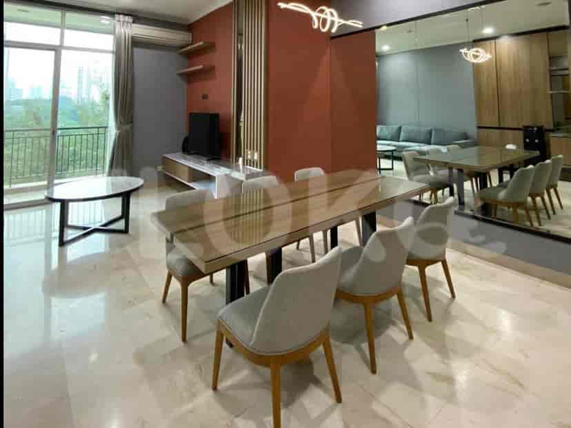 A dining area adjacent to the living room, featuring a long dining table with chairs and a large mirror.
