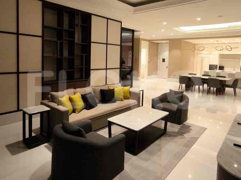 A spacious living room with a large sectional sofa, coffee table, and a built-in shelving unit.