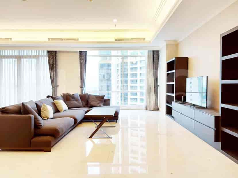 A living room featuring a grey L-shaped sofa, a coffee table, and a built-in entertainment unit with a TV.