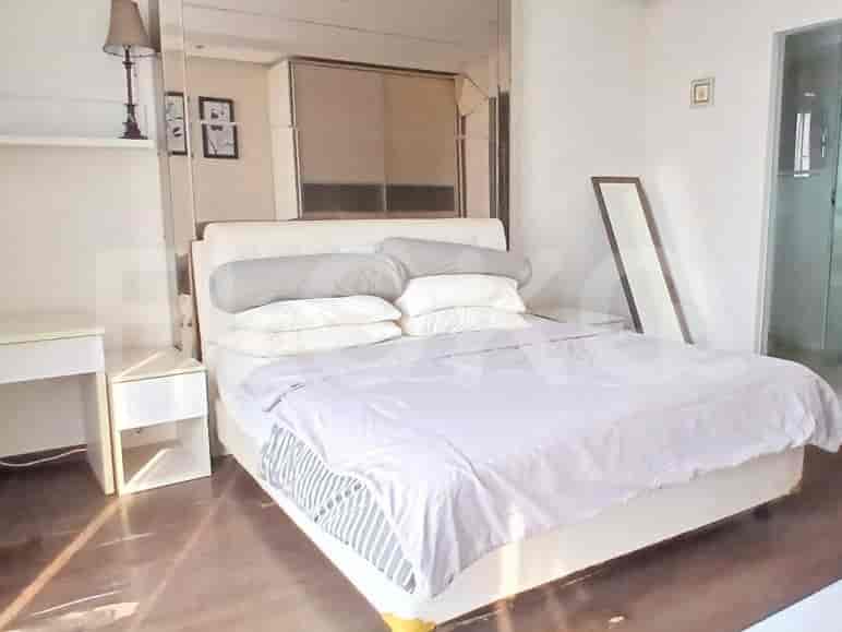 A bedroom with a king-size bed, mirrored wardrobe, and a white vanity table.