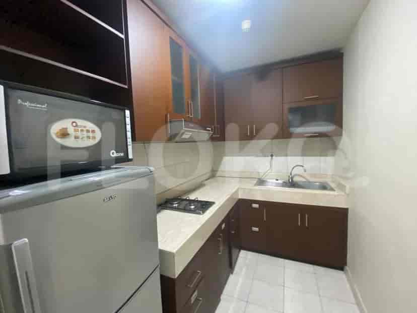A compact kitchen with dark wood cabinets and stainless steel appliances.