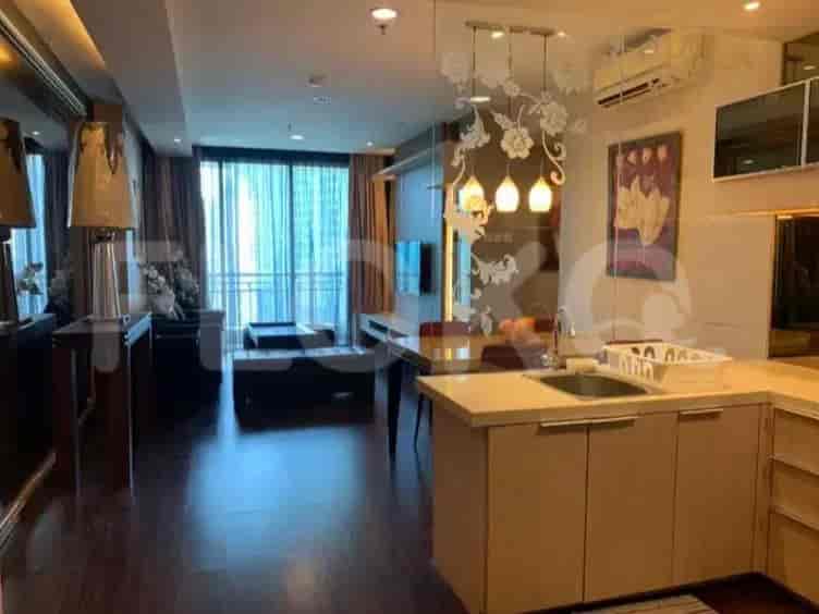Dapur dan ruang makan terbuka dengan kabinet kayu, wastafel, dan meja makan.