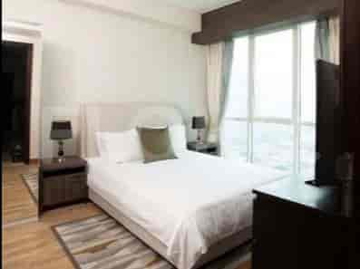 Bedroom with a bed, nightstands, and a view.