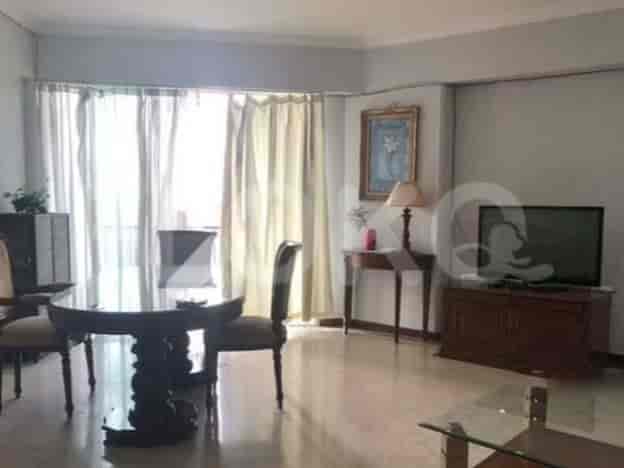 A living room with a dining table, chairs, a sofa, and a TV console.
