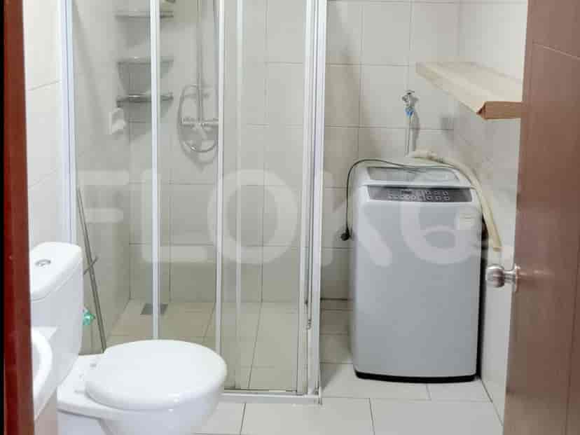 Kamar mandi dengan toilet, bilik shower, dan mesin cuci.