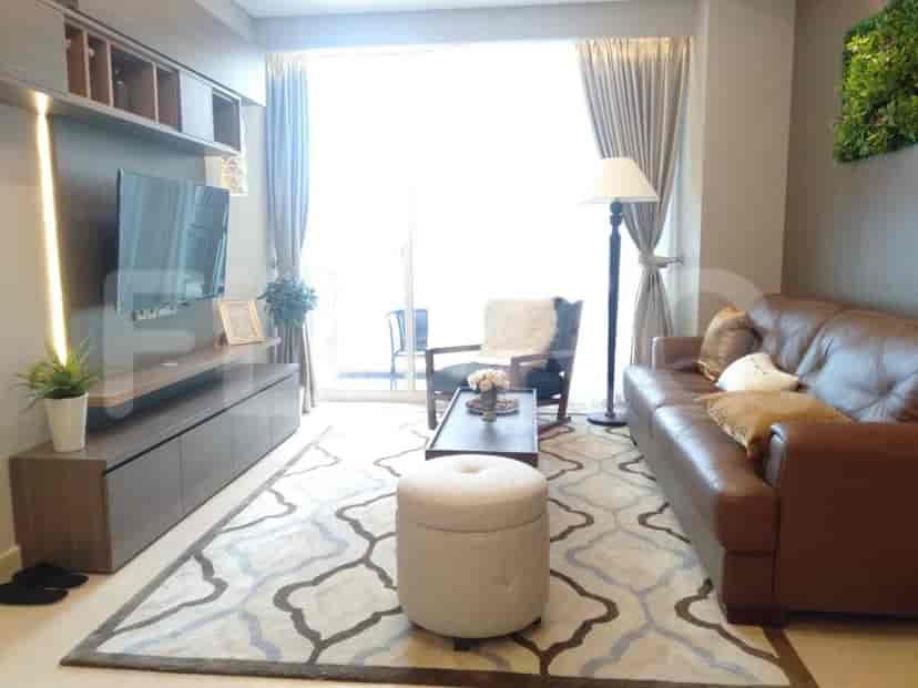 A modern living room with a leather sofa, patterned rug, and floor-to-ceiling windows.
