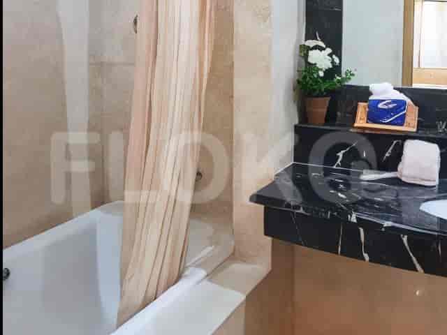 A bathroom with a bathtub, sink, and neutral-toned decor.