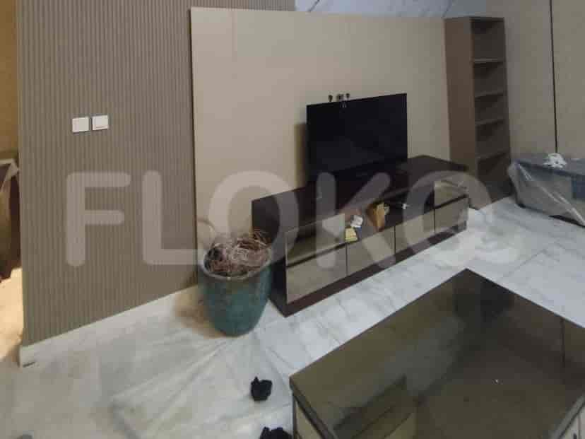 A spacious living room with a TV stand and decor.