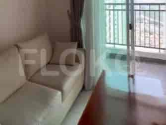 A living space with a beige sofa next to a balcony.