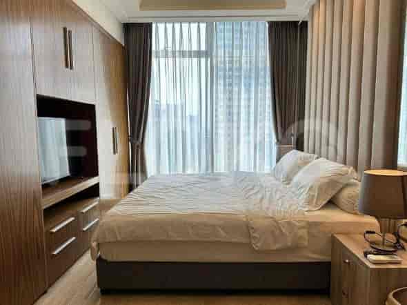 A modern bedroom featuring a king-size bed with white bedding and dark wooden cabinets.
