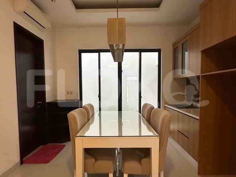 A kitchenette or bar area with wooden cabinets, a sink, and a mirrored backsplash.