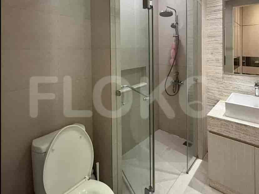 A modern bathroom with a glass-enclosed shower, a toilet, and a vanity with a sink.