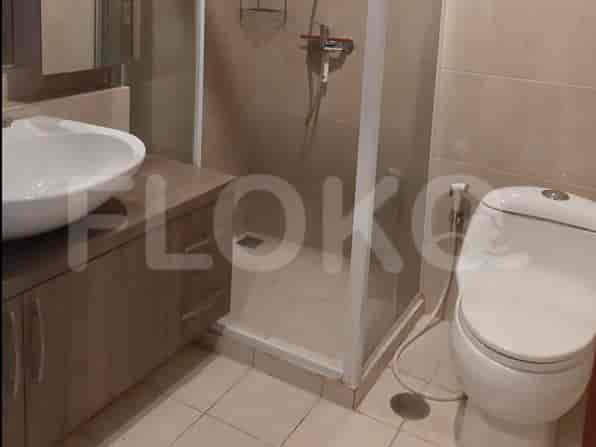 A bathroom with a sink, toilet, and a glass-enclosed shower stall.
