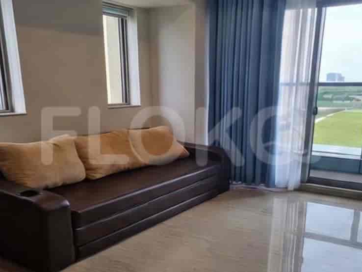 A convertible sofa in a living area with large windows and blue curtains.