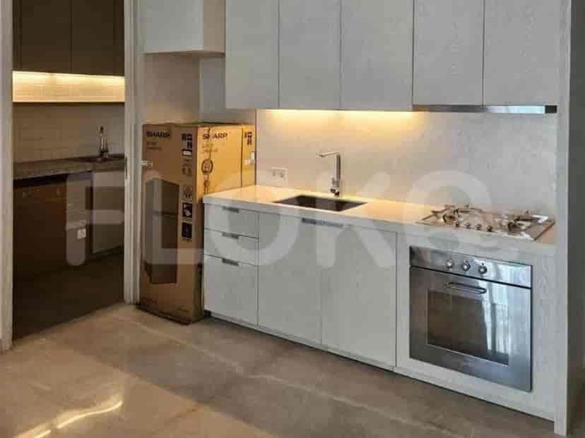 A modern kitchen with white cabinets, a sink, a stovetop, and an oven.