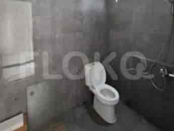 A bathroom with a toilet, shower, and grey tiled walls.