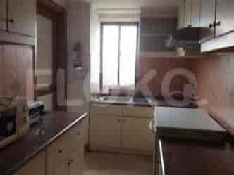 A kitchen area with a sink, stove, and cabinets.