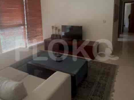A living room with a sofa, coffee table, and a TV stand.