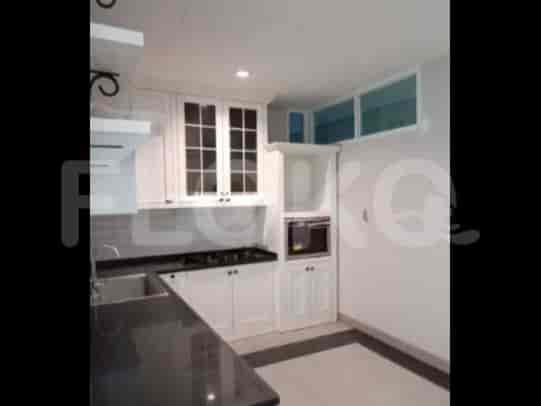A modern kitchen with white cabinets, dark countertops, and built-in appliances.