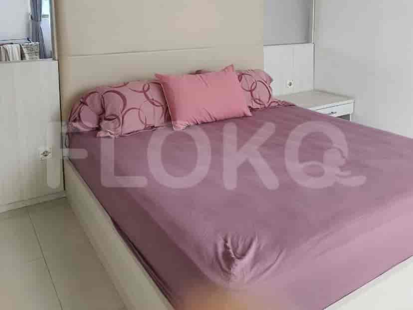A bedroom with a queen-sized bed and a bedside table.