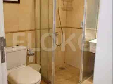 A bathroom with a toilet and a glass-enclosed shower.