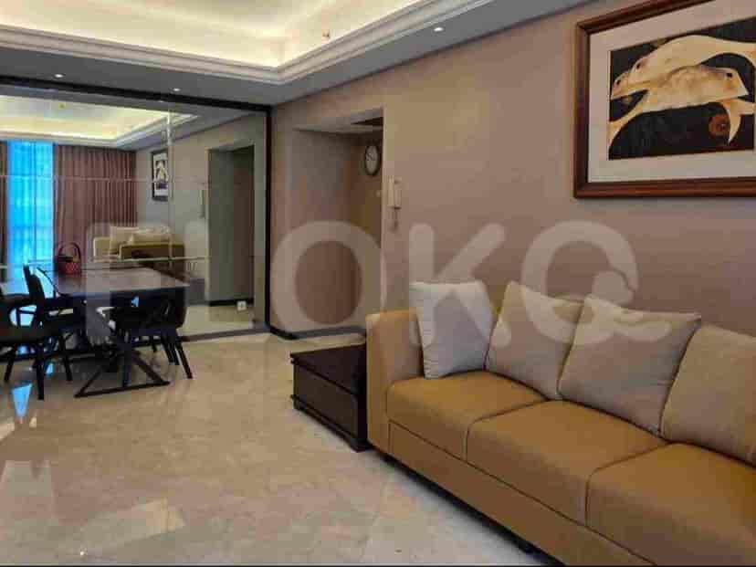 Area tamu dan ruang makan gabungan dengan meja makan yang tertata, sofa, dan cermin besar yang memantulkan ruangan.