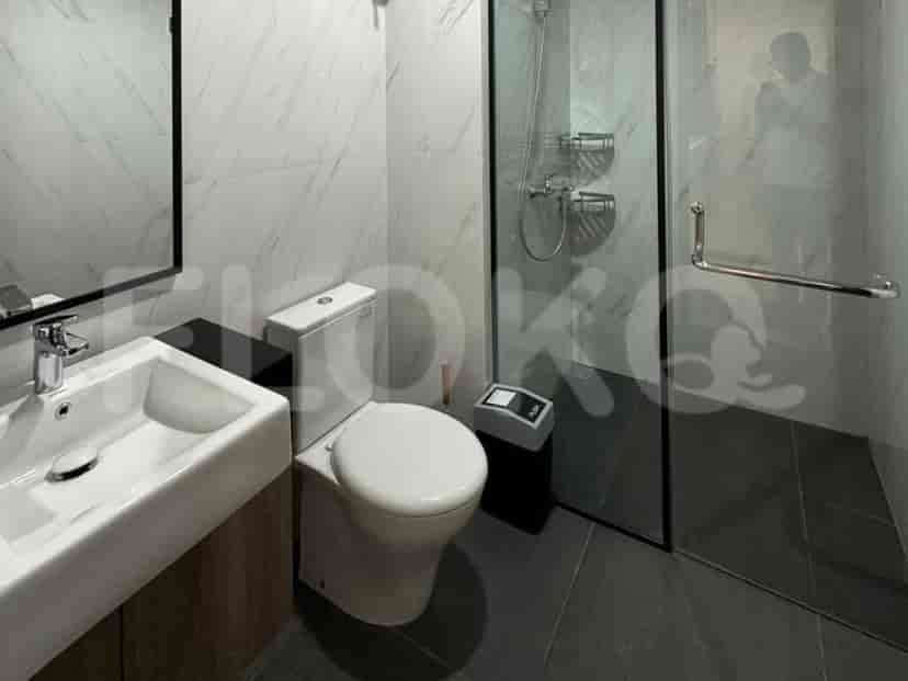 A modern bathroom with a sink, toilet, and a glass-enclosed shower.