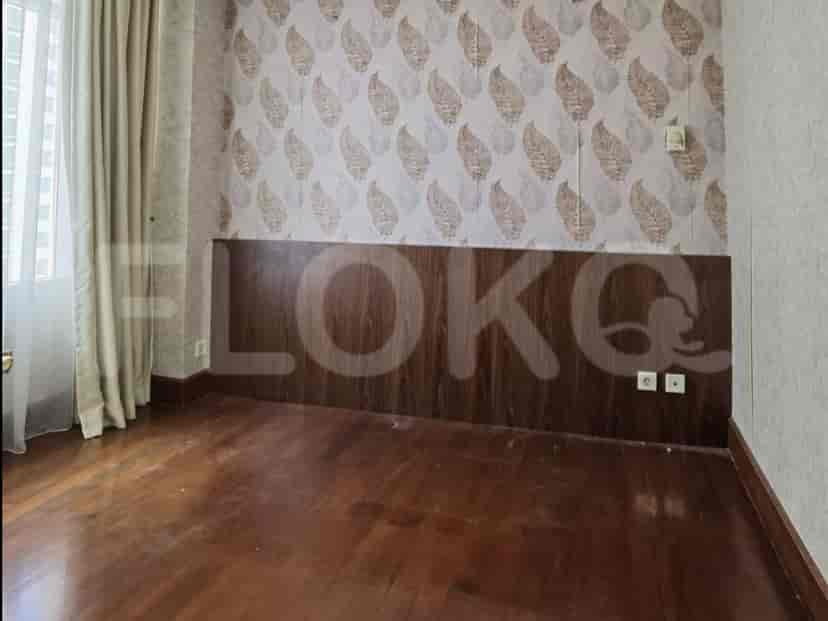 A bedroom with wooden flooring and patterned wall panels.