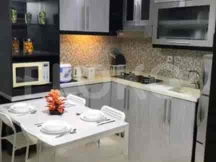 Dapur ringkas dengan lemari abu-abu, kompor gas, dan meja makan dengan kursi.