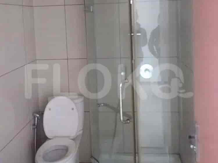 Kamar mandi modern dengan shower kaca dan toilet.
