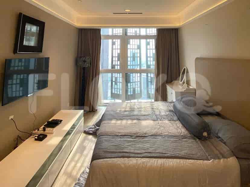 Bedroom with a bed, TV, and curtains.