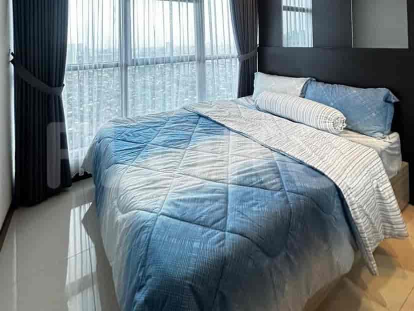 Sebuah kamar tidur dengan tempat tidur ukuran queen, seprai biru dan putih, dan jendela besar dengan gorden gelap.