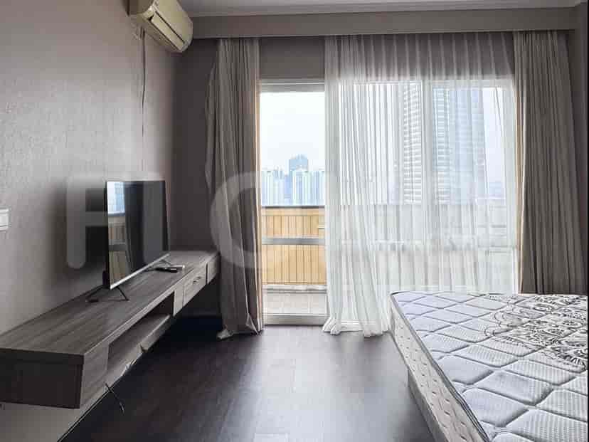 A bedroom with a TV mounted above a floating console.