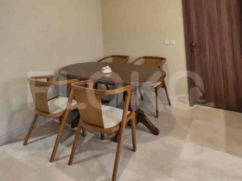 A dining area with a wooden oval dining table and four wooden chairs.
