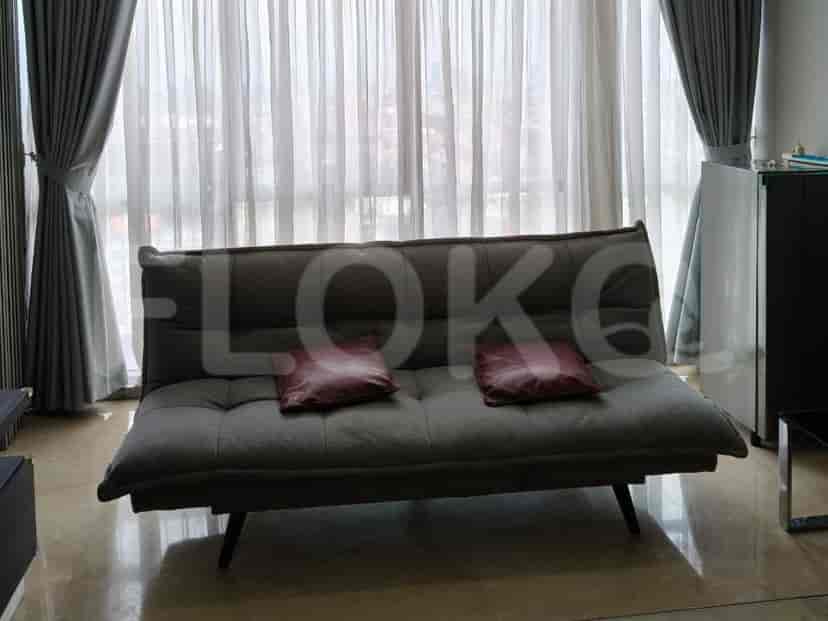 A close up view of the grey sofa with cushions and curtains.