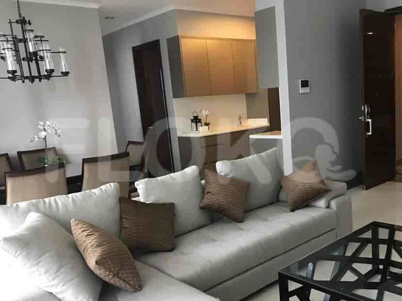 Spacious living room with L-shaped sofa, dining area, and access to kitchenette.