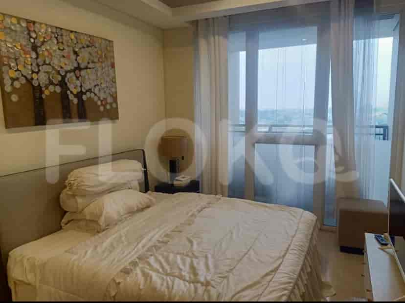 A bedroom with a bed, curtains, and a window.