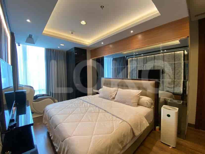 A bedroom featuring a king-size bed, a massage chair, a TV, and mirrored wardrobe doors.