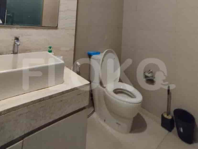 A bathroom with a sink, toilet, and toilet brush.