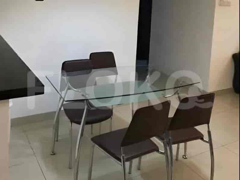Meja makan berlapis kaca dengan empat kursi berlapis coklat dan kaki logam.