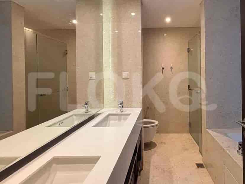 A luxurious bathroom with a double vanity, a large mirror, a toilet, and a glass-enclosed shower.
