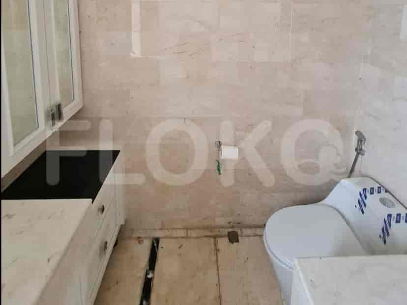 Bathroom with toilet and marble walls.