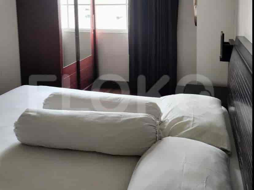 Kamar tidur dengan tempat tidur besar, jendela, dan lemari pakaian cermin.