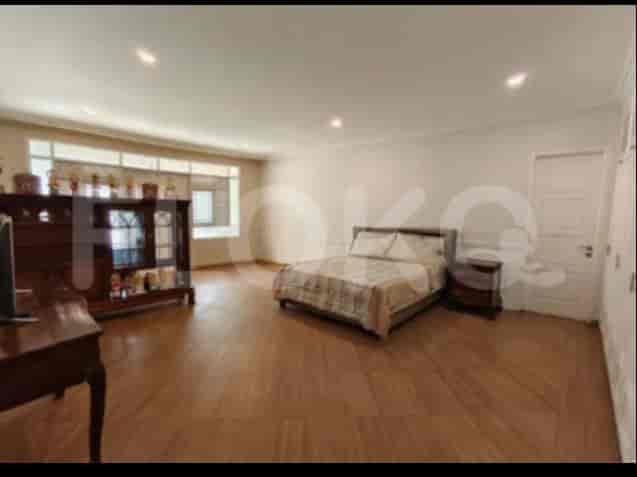 A spacious bedroom with a king-size bed, a large window, and a cabinet.