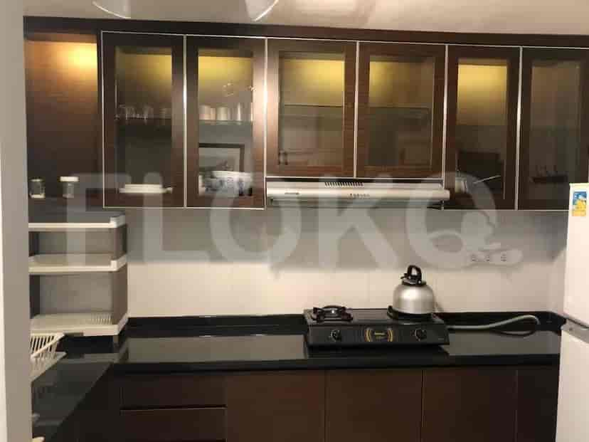 Dapur ringkas dengan lemari kayu gelap, meja hitam, dan kompor gas.