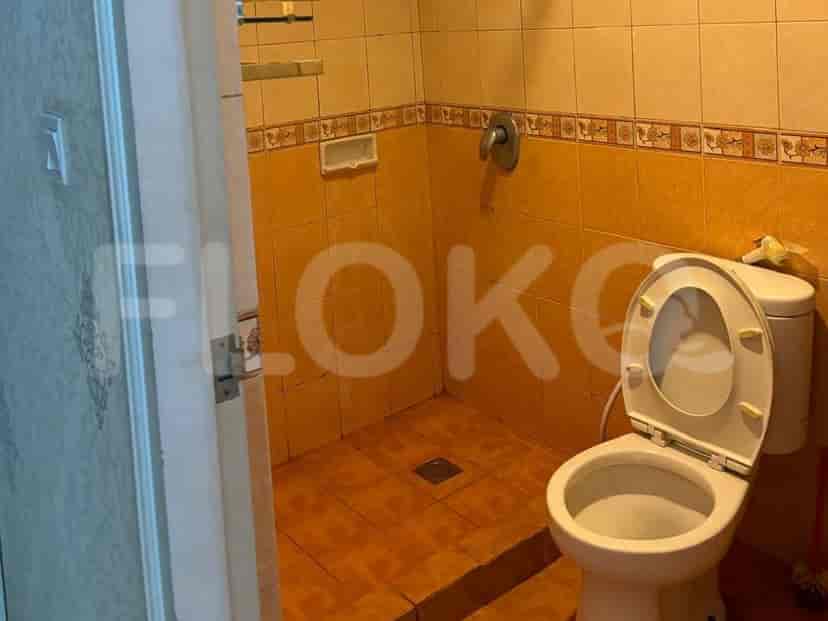 A simple bathroom featuring a toilet and a shower area.
