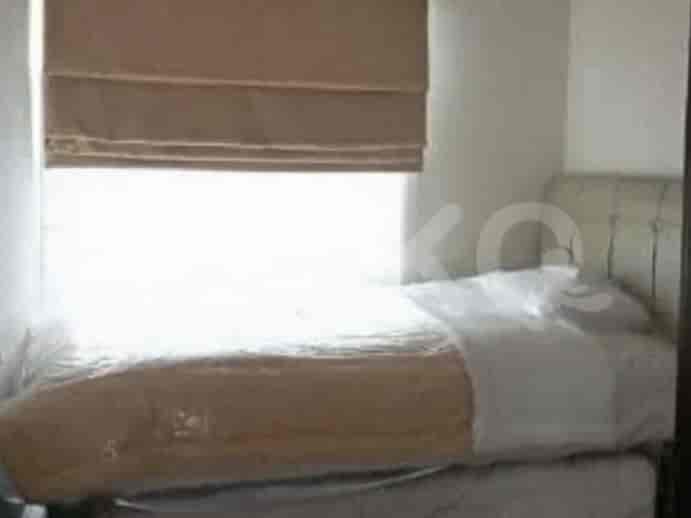 A bedroom with a single bed, white bedding, and a window with a roman blind.